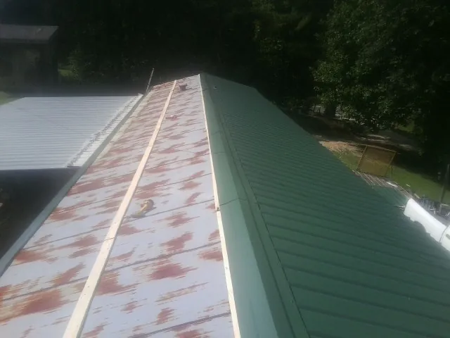 Old rusted panels beside newly installed green metal roofing — Wind Damage Roof Repair by Roofing Brothers in Hurst