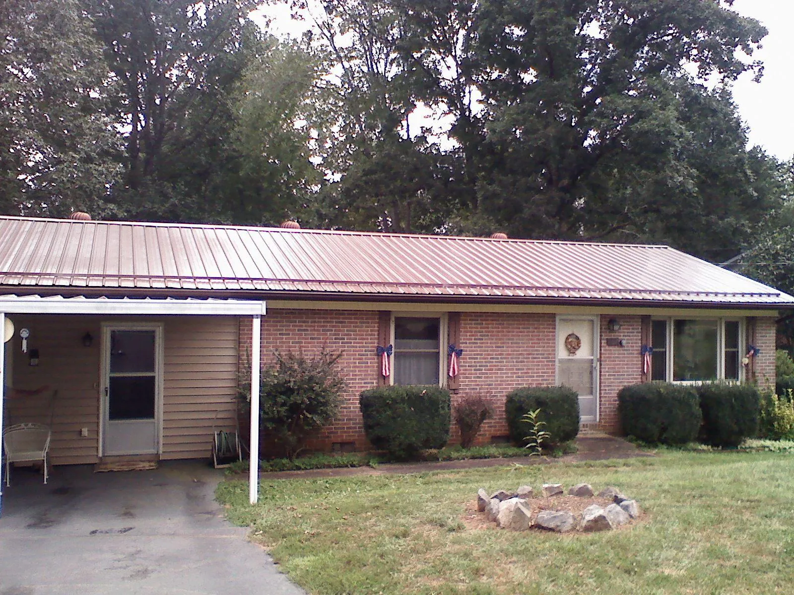 Bronze metal roof and carport on a brick ranch home — Roof Repair work by our crew in Hurst